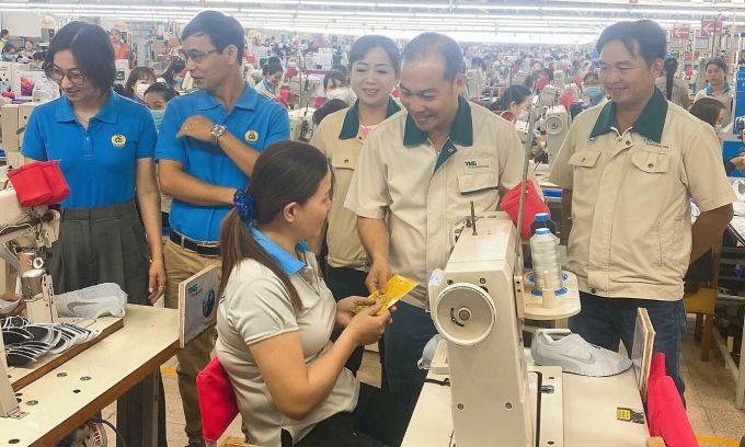 Herr Dinh Sy Phuc gibt den Arbeitern am Tet-Fest 2023 Tet-Glücksgeld. Foto: An Phuong