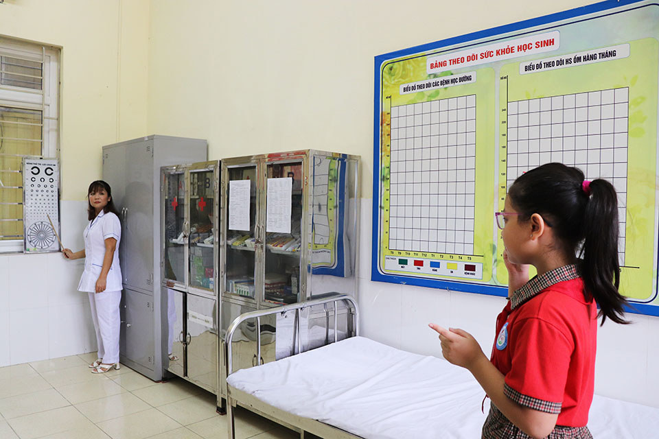 Medical staff check students' eyesight.