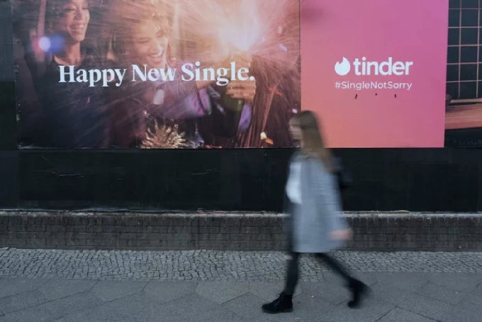 A girl walks past a Tinder billboard in Berlin, Germany. Photo: Newsweek