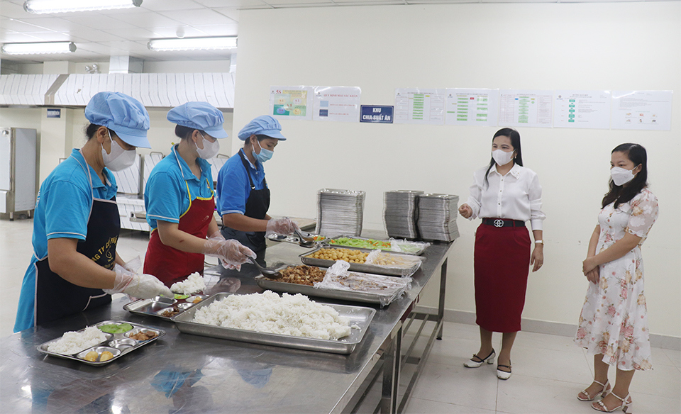 Lehrerin Hoang Thi To Oanh – stellvertretende Schulleiterin der Nguyen Thi Minh Khai Secondary School und Vertreter der Eltern der Schüler beaufsichtigen das Küchenpersonal bei der Essensausgabe an die Schüler.