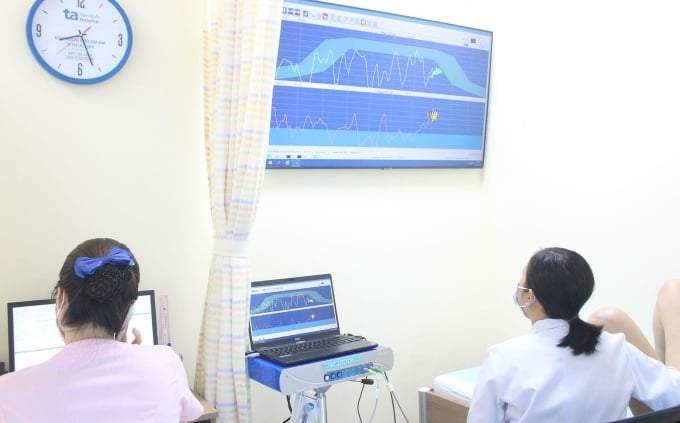 Bác sĩ điều trị cho chị Nga bằng máy tập sàn chậu có chế độ kích thích điện cơ và phản hồi sinh học. Ảnh: Tuệ Diễm