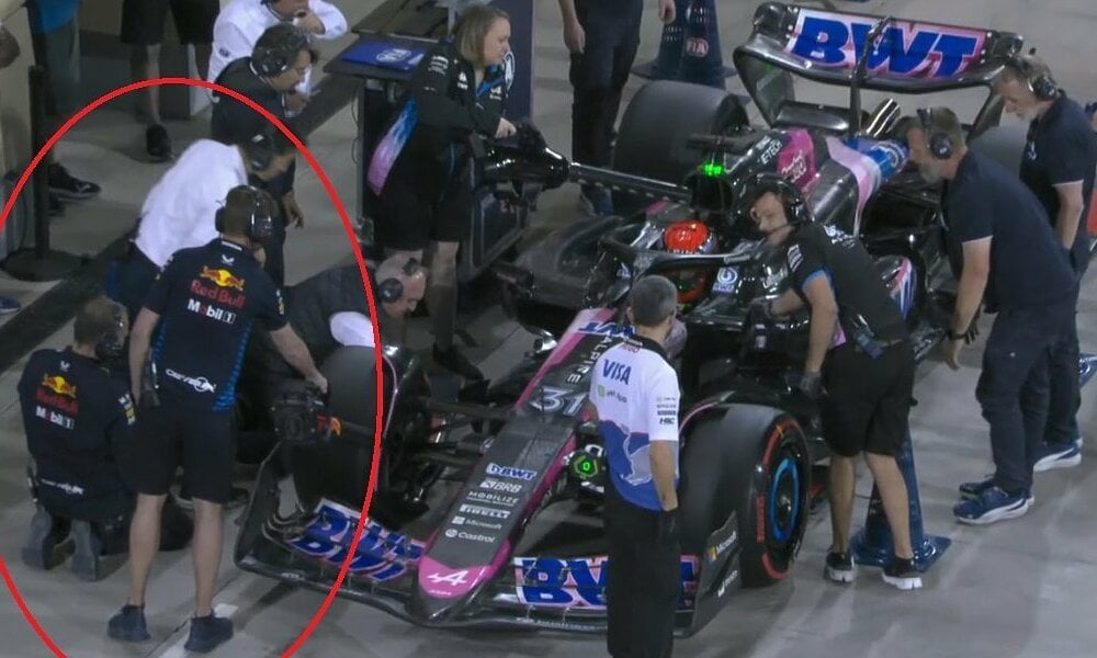 Un ingeniero de Red Bull ayuda a un competidor a enfriar su coche durante la carrera