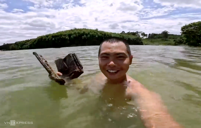 Hoa dived down to pick up bricks, tiles, and sticks at the bottom to prepare for the big battle. Photo: Le Hoa