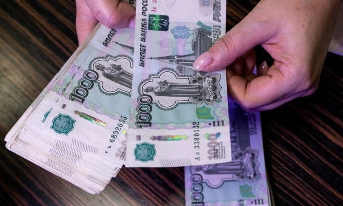 An employee counts 1,000 ruble notes at a bank in Russia. Photo: Reuters