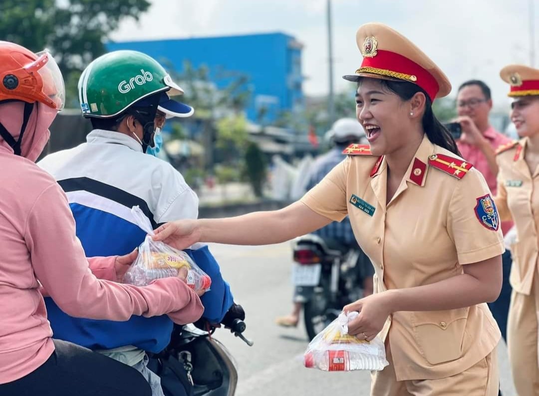 CSGT Bến Tre phát nước suối cho người dân qua cầu Rạch Miễu về quê đón tết- Ảnh 1.