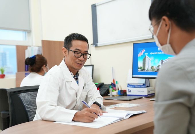 Le docteur Khang conseille les patients sur leur régime de traitement. Photo : Huu Trung