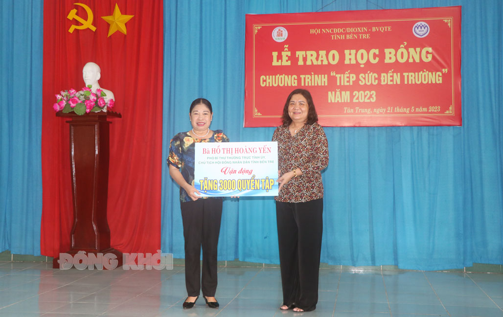 Phó bí thư thường trực Tỉnh ủy - Chủ tịch HĐND tỉnh Hồ Thị Hoàng Yến trao bảng tượng trưng hỗ trợ 3 ngàn quyển tập.