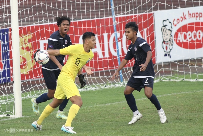 Guam player (in black shirt) tries to take the ball from Singapore goalkeeper after scoring the equalizer in the 88th minute. Photo: Hieu Luong