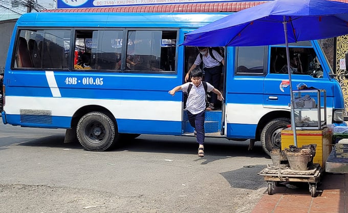 Học sinh trường tiểu học Long Bình Tân (TP Biên Hòa, Đồng Nai) nhảy xuống từ xe đưa rước trưa 15/2/2023. Ảnh: Phước Tuấn