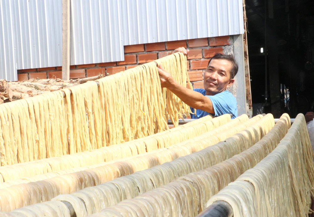 Workers dry tofu skin on racks. (Photo: Le Thuy Hang/VNA)