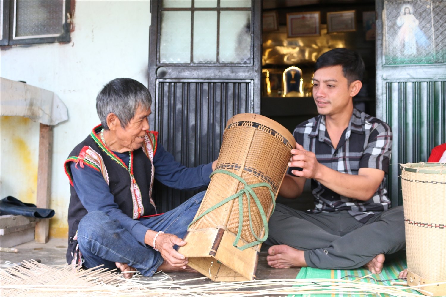 Ông A Biu (bên trái) – Già làng, Người có uy tín thôn Kei Joi, xã Đăk Xú, huyện Ngọc Hồi hướng dẫn thế hệ trẻ cách làm nghề đan lát truyền thống của dân tộc