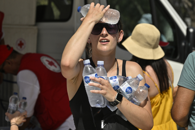 7月20日、アテネでギリシャ赤十字社の車両から冷たい水を受け取る観光客。写真：AFP