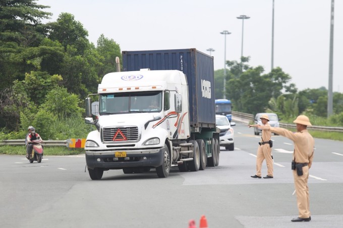 Traffic police check containers at the gateway to Hanoi. Photo: Gia Chinh