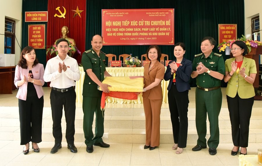 Während der thematischen Wählerkontaktsitzung in Hanoi Juli 2023, Delegation der Abgeordneten der Nationalversammlung von Hanoi Innere Koordinierung der Blattvergabe große rote Flagge mit gelbem Stern des Vaterlandes zum Aufhängen am Fahnenmast von Lung Cu