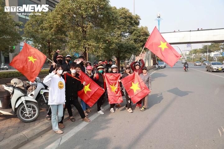 Fans mit roten Fahnen mit gelben Sternen warten auf der Vo Chi Cong-Straße vom Flughafen Noi Bai ins Zentrum von Hanoi auf das vietnamesische Team.