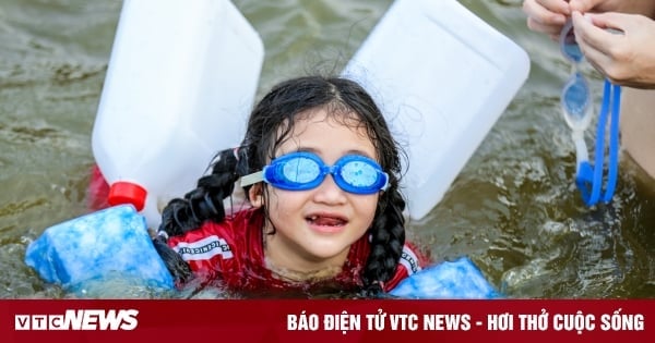 Los niños de Hanoi disfrutan refrescándose en un lago milenario