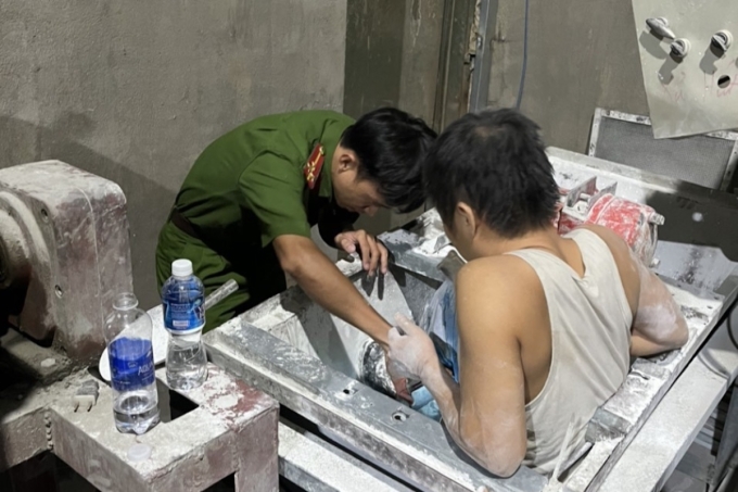 Cảnh sát giải cứu nam công nhân kẹt trong máy trộn xi măng. Ảnh: Thái Hà