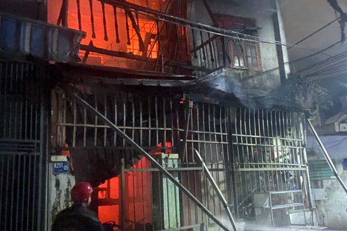 La police s'est approchée de la maison en feu pour éteindre l'incendie. Photo : Duc Anh