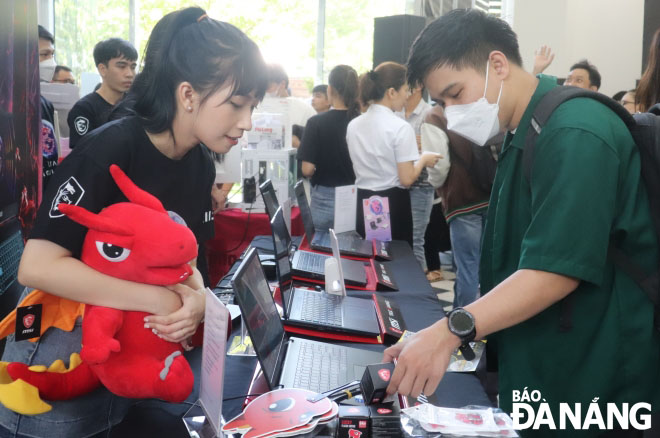 Los estudiantes se informan sobre las vacantes de empleo en el stand. Foto: NGOC HA