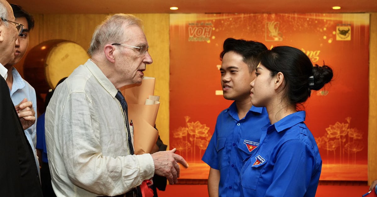 Jóvenes de la ciudad de Ho Chi Minh interactúan con dos personas que cuelgan banderas vietnamitas en la Catedral de Notre Dame.