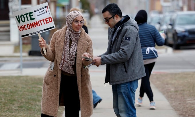Seorang pengundi di Dearborn, Michigan, memegang papan tanda menggesa pilihan tanpa komitmen untuk mengundi Presiden Joe Biden pada 27 Februari. Foto: AFP