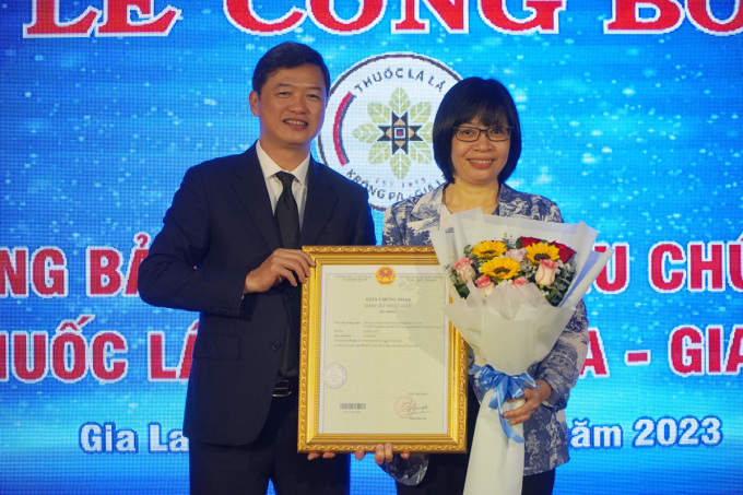 Ông Lưu Hoàng Long, Cục trưởng Cục Sở hữu trí tuệ trao văn bằng bảo hộ cho bà Nguyễn Thị Thanh Lịch, Phó chủ tịch UBND tỉnh Gia Lai. Ảnh: Trần Hóa