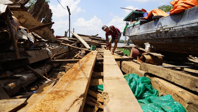 Los trabajadores seleccionan las tablas adecuadas para fabricar los marcos de reemplazo. Foto: Hoang Nam