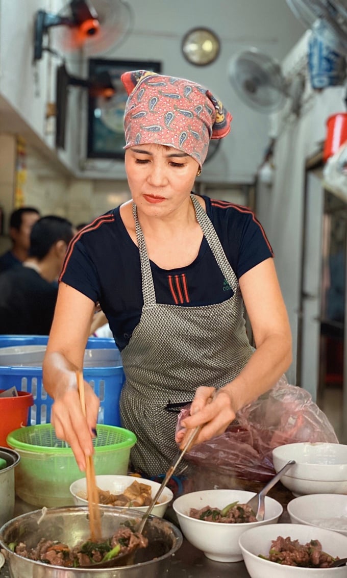 La Sra. Ha, la actual propietaria, está preparando pho de carne frita.