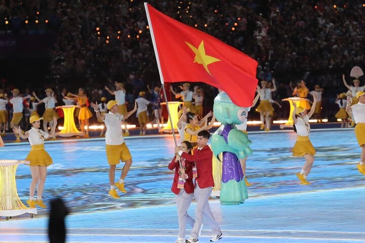 Nguyen Huy Hoang and Nguyen Thi Huong carried the national flag and led the Vietnamese sports delegation in the parade. (Photo: Duc Thien)