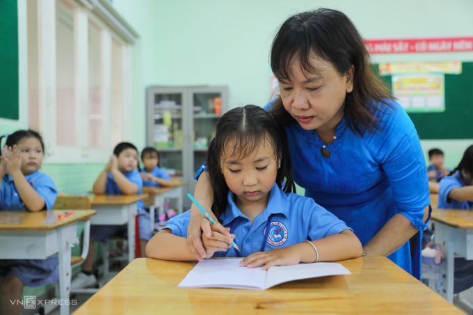 Los maestros de la escuela primaria Dinh Tien Hoang (distrito 1, ciudad de Ho Chi Minh) dan clases a los alumnos de primer grado el primer día de clases del año escolar 2022-2023. Foto: Quynh Tran