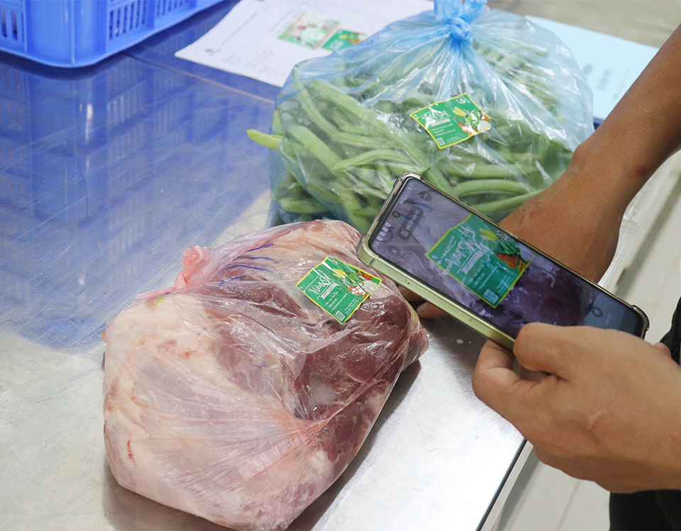 Elternvertreter scannen QR-Codes, um die Herkunft der Lebensmittel in der Kantine der Nguyen Thi Minh Khai Secondary School zu verfolgen.