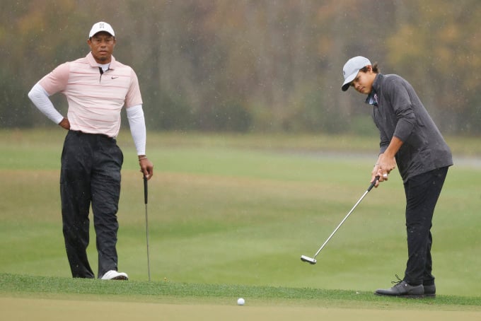 Charlie Woods putsts as his father, Tiger Woods, looks on on the 14th hole of the first round of the PNC Championship at The Ritz-Carlton, Orlando, USA on December 16. Photo: AFP