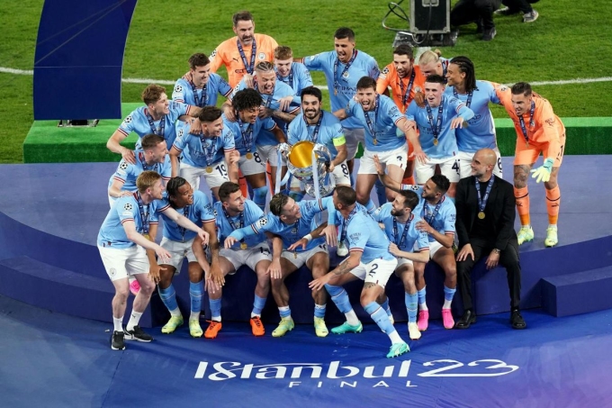 Guardiola (en maillot noir, assis à droite) attend que le capitaine Gundogan soulève le trophée de la Ligue des champions au stade Atatürk, à Istanbul, en Turquie, le soir du 10 juin, complétant ainsi un triplé historique pour Man City. Photo : PA