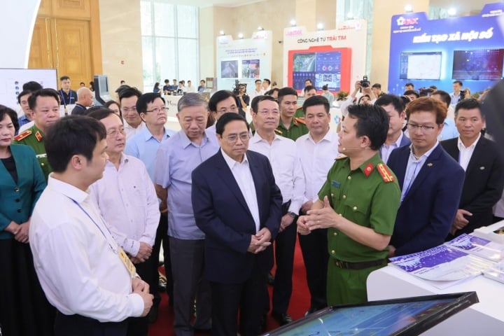 Le Premier ministre Pham Minh Chinh et les dirigeants des ministères et des branches au stand d'exposition des produits appliquant les données sur la population, l'identification et l'authentification électronique le 12 juillet 2023. (Photo NH)