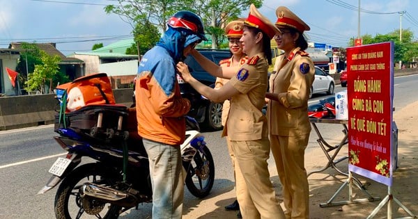 Una agente de policía de tráfico de Quang Nam entrega y coloca cascos a las personas que regresan a casa para el Tet