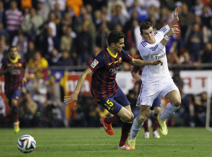 Bale đi bóng qua Marc Bartra trước khi ghi bàn ấn định tỷ số 2-1 cho Real trong trận chung kết Cup Nhà Vua Tây Ban Nha với Barca trên sân Mestalla Valencia ngày 16/4/2014. Ảnh: Reuters