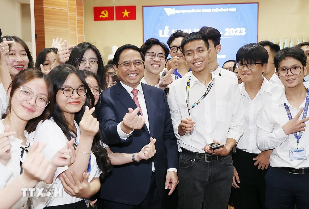 El primer ministro Pham Minh Chinh con estudiantes de la Universidad Nacional de Ciudad Ho Chi Minh. (Foto: Duong Giang/VNA)