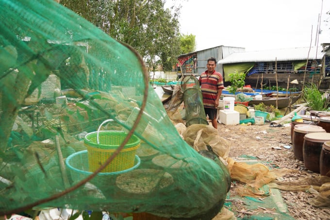 La familia de la Sra. Phung está remendando bolsas de pesca durante la temporada de inundaciones. Foto: Hoang Nam