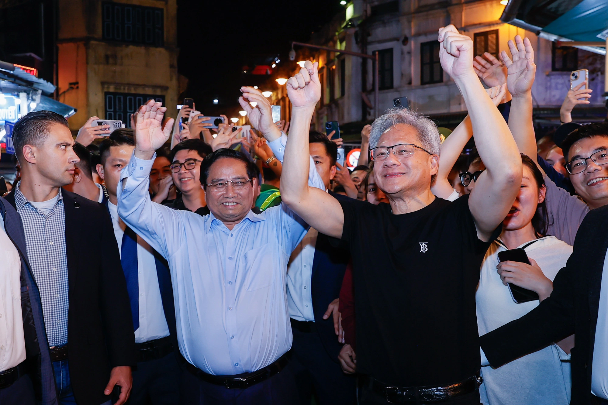 El primer ministro Pham Minh Chinh y el presidente de Nvidia caminan del brazo por Hanoi de noche