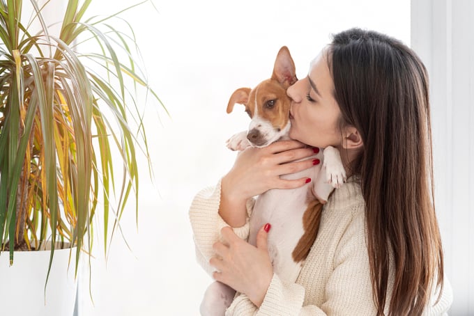 Eine Frau küsst ihren Hund. Foto: Freepik