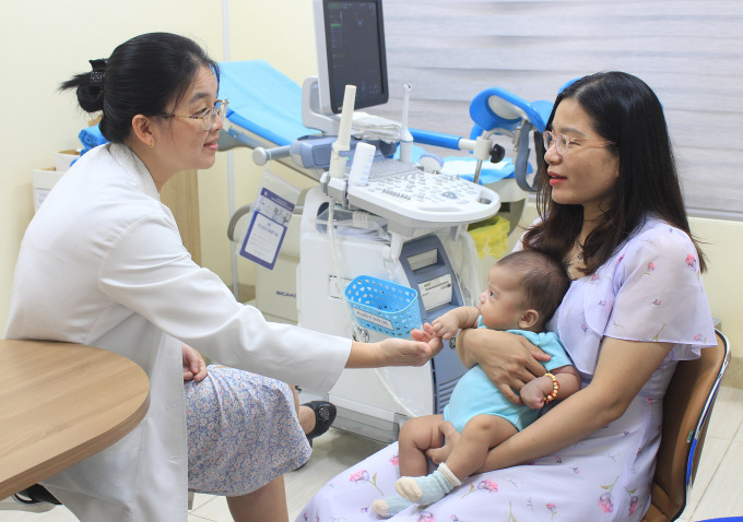 Una paciente infértil visita al Dr. Giang Huynh Nhu después de un tratamiento exitoso y de dar a luz a un bebé sano. Foto: Hoai Thuong