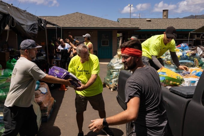 Voluntarios reparten comida a las mascotas en el Centro Humanitario Maui en Puunene, Maui Central, Hawaii, el 15 de agosto. Foto: AFP