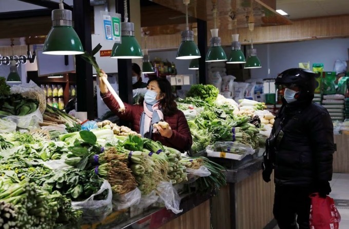 Menschen kaufen auf einem Markt in Peking (China) ein. Foto: Reuters