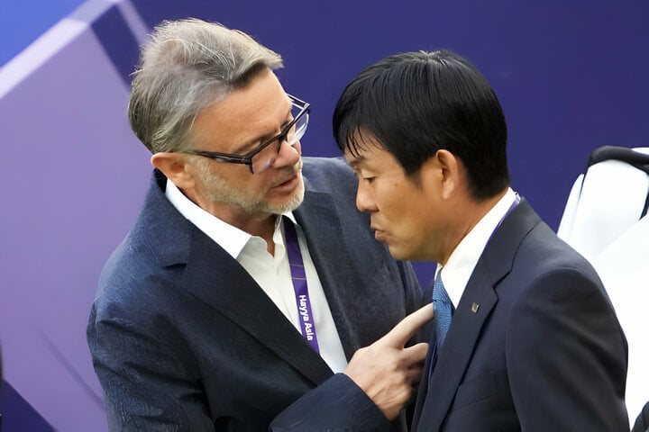 Coach Hajime Moriyasu talks with Mr. Philippe Troussier before the match.