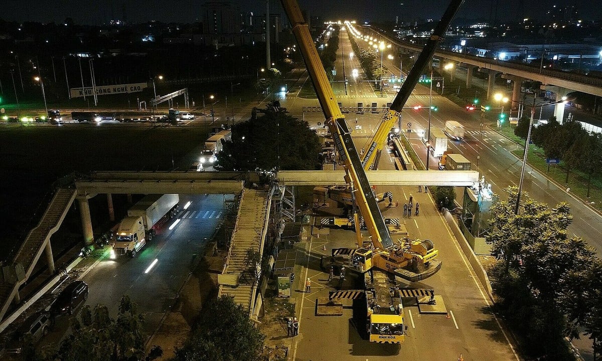 Installation de la première poutre de pont piétonnier sur l'autoroute reliant le métro n° 1