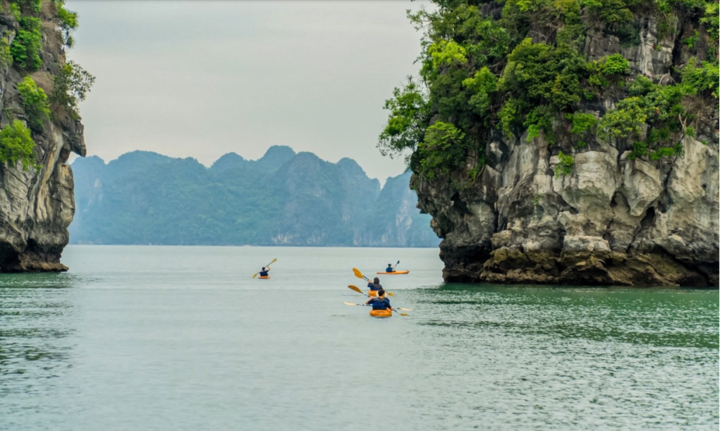 Tourists experience kayaking on Ha Long Bay.