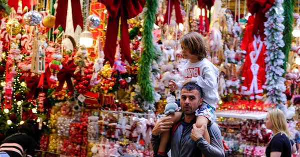 Ausländische Touristen genießen die weihnachtlichen Farben auf der Hang Ma Straße