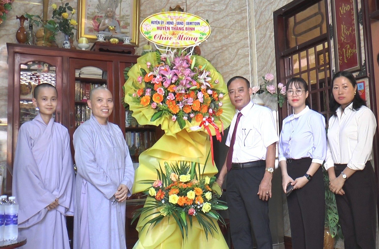 นายเล กวาง ฮาต รองเลขาธิการพรรคเขต มอบดอกไม้แสดงความยินดีกับพระภิกษุและภิกษุณีวัดบิ่ญเกว ภาพโดย : D.H