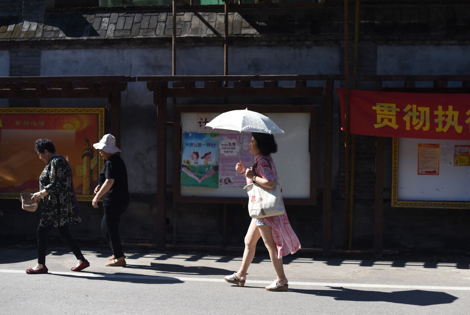 中国・北京では、人々が日差しを避けるために傘を使っている。写真：AFP/VNA