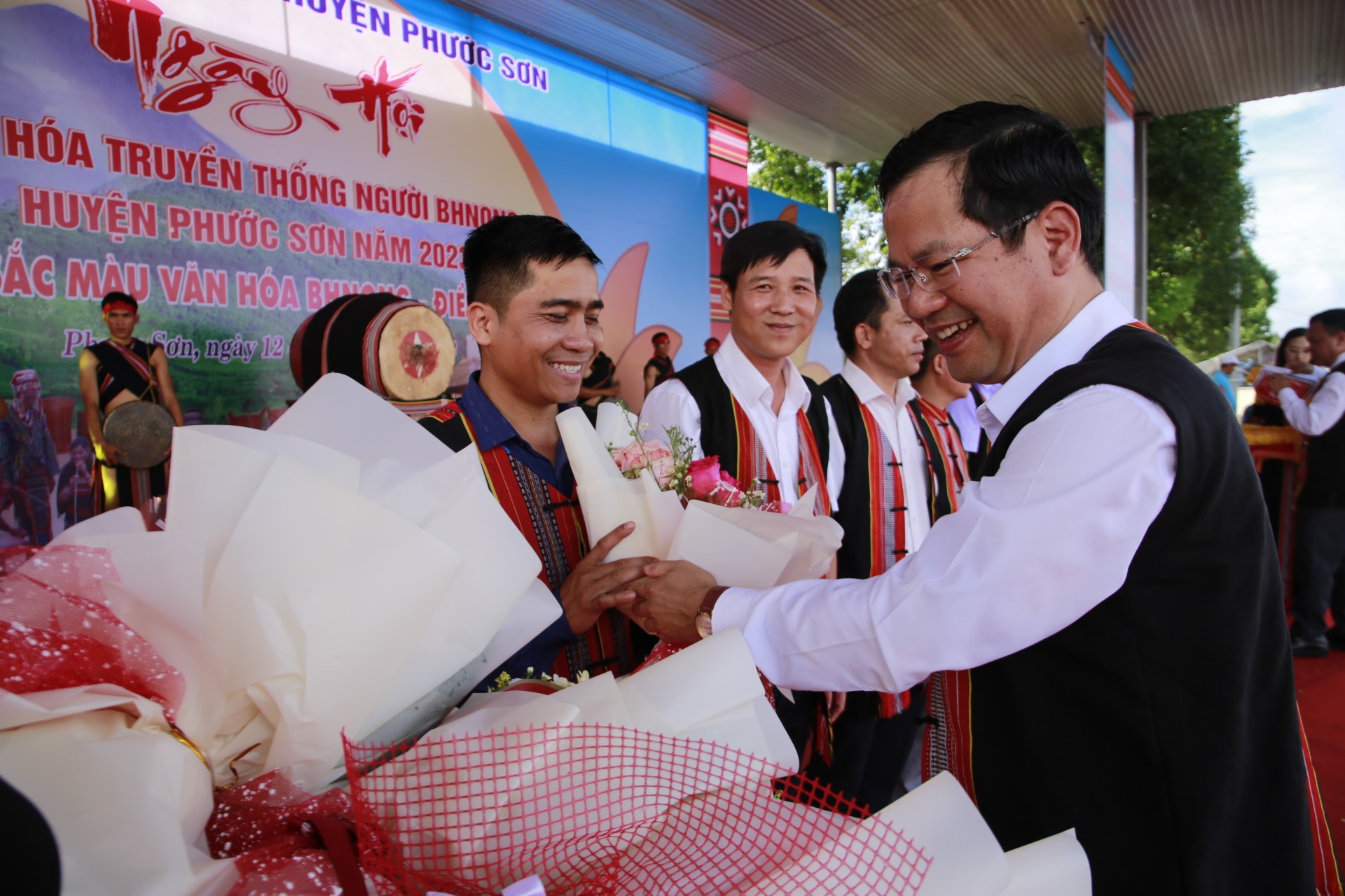 Phuoc Son district leaders presented flowers and souvenir flags to the delegations participating in the festival. Photo: A.N